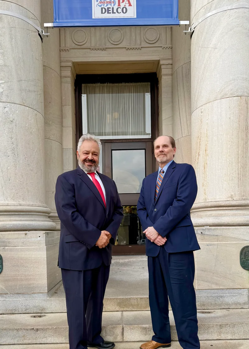SKRR founding partners Vasil L. Kirifides and Mark R. Schmidt standing together outside a stone building