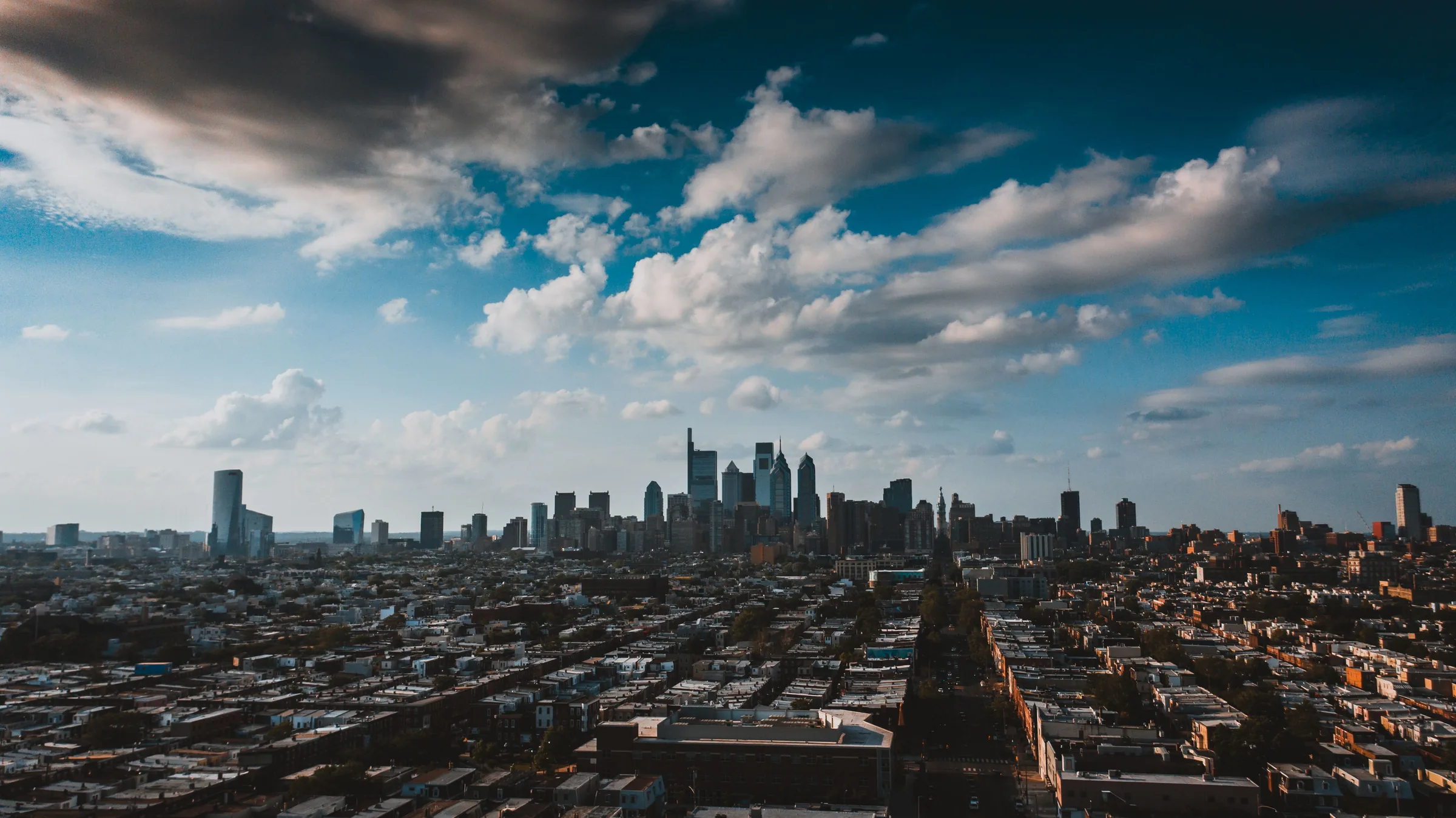 Philadelphia skyline and surrounding neighborhoods beneath dramatic clouds