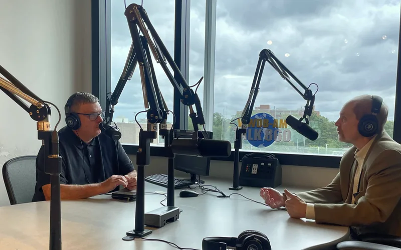 Two speakers in conversation at the microphones in the WWDB 860 AM studio